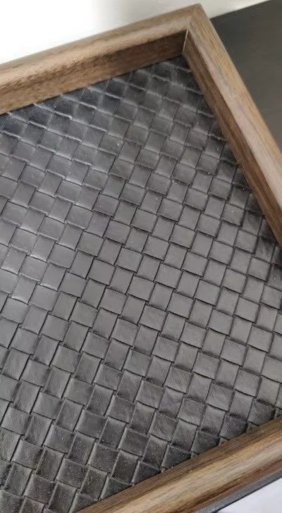 Svart pyntebrett med flettet bunn og trefarget kant