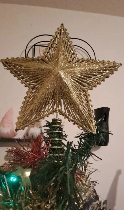 Juletrestjerne i gull på toppen av et juletre