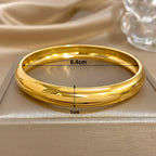 Gullfarget armring med innvendig diameter 6,4 cm og bredde 1 cm markert