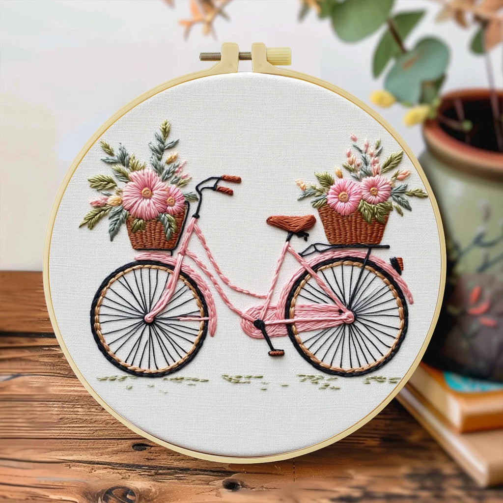 Det ferdige sykkelmotivet i broderirammen på et trebord