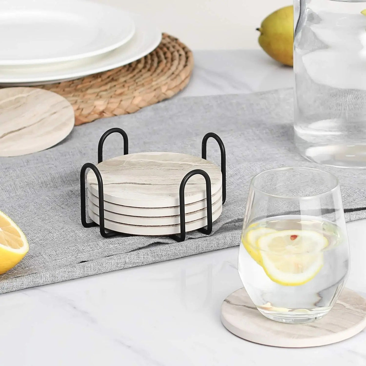 Glassbrikkene i holderen på en grå duk og en brikke under et glass vann med sitron