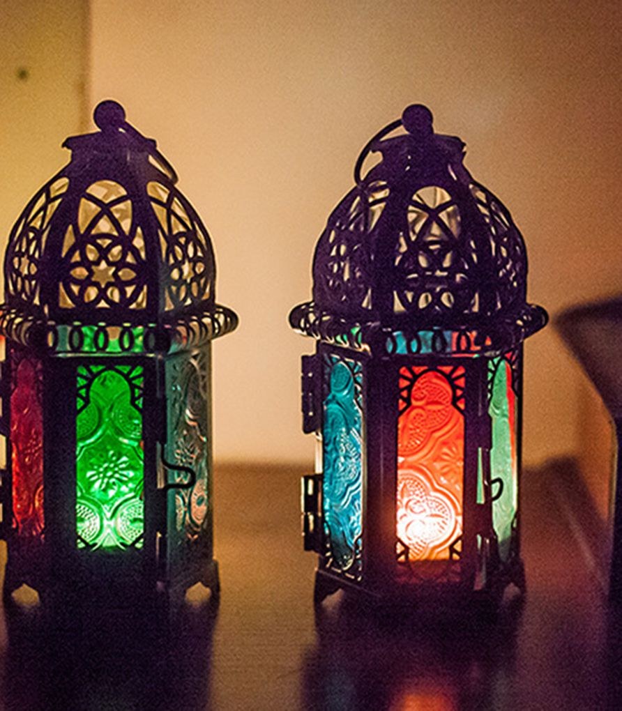 To svarte lyslykter med grønt, rødt og blått glass