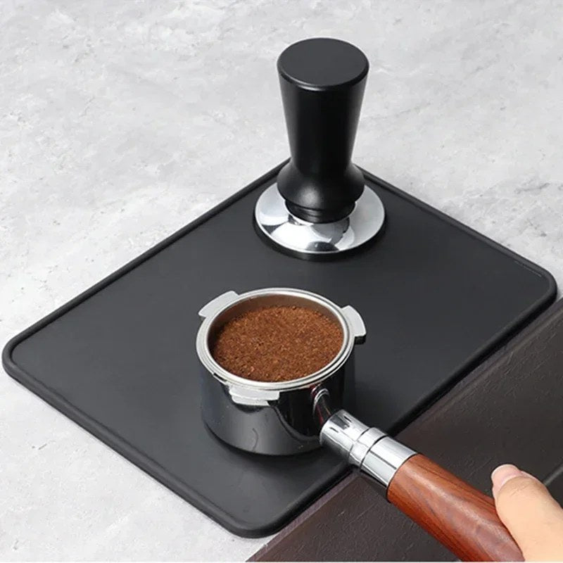 Tampermatten sett ovenfra med en tamper og en portafilter med kaffe