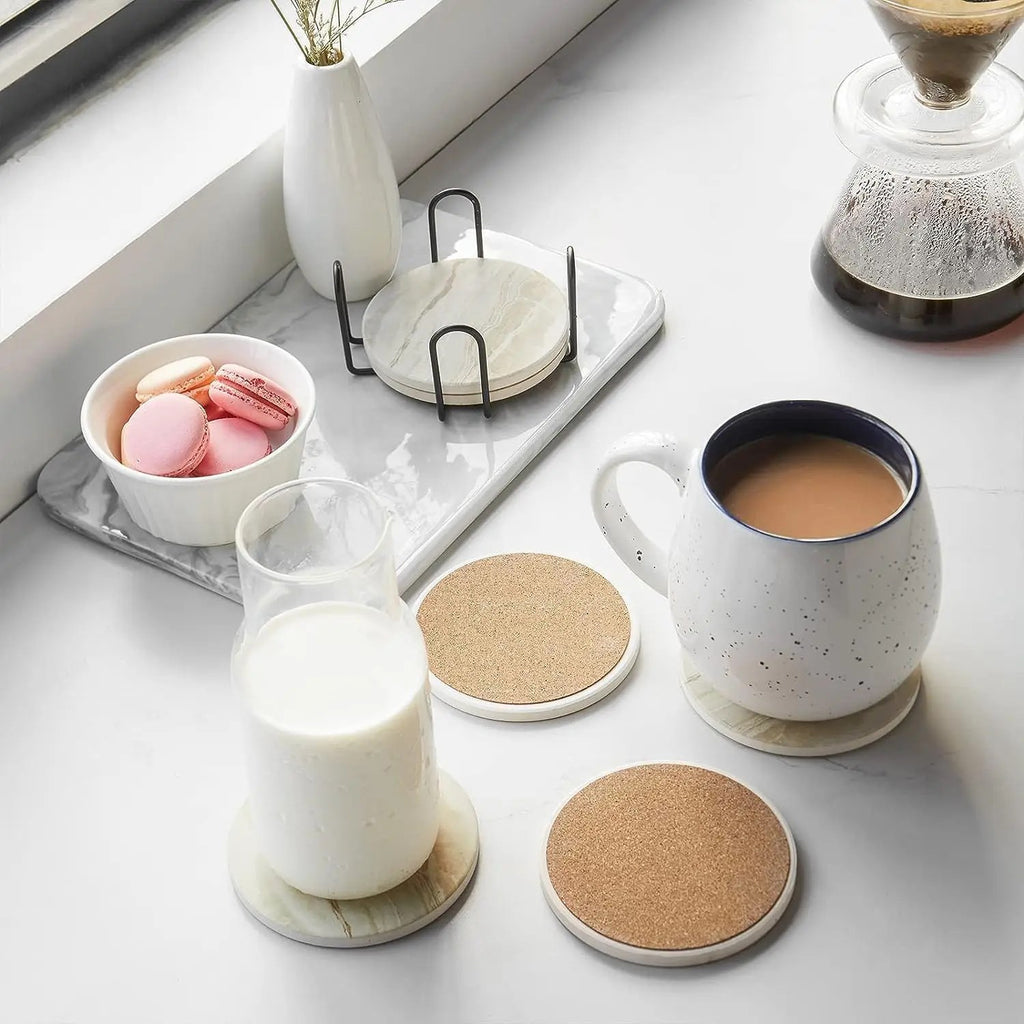 Glassbrikker under et krus kaffe og et glass melk; to brikker ligger med korksiden opp