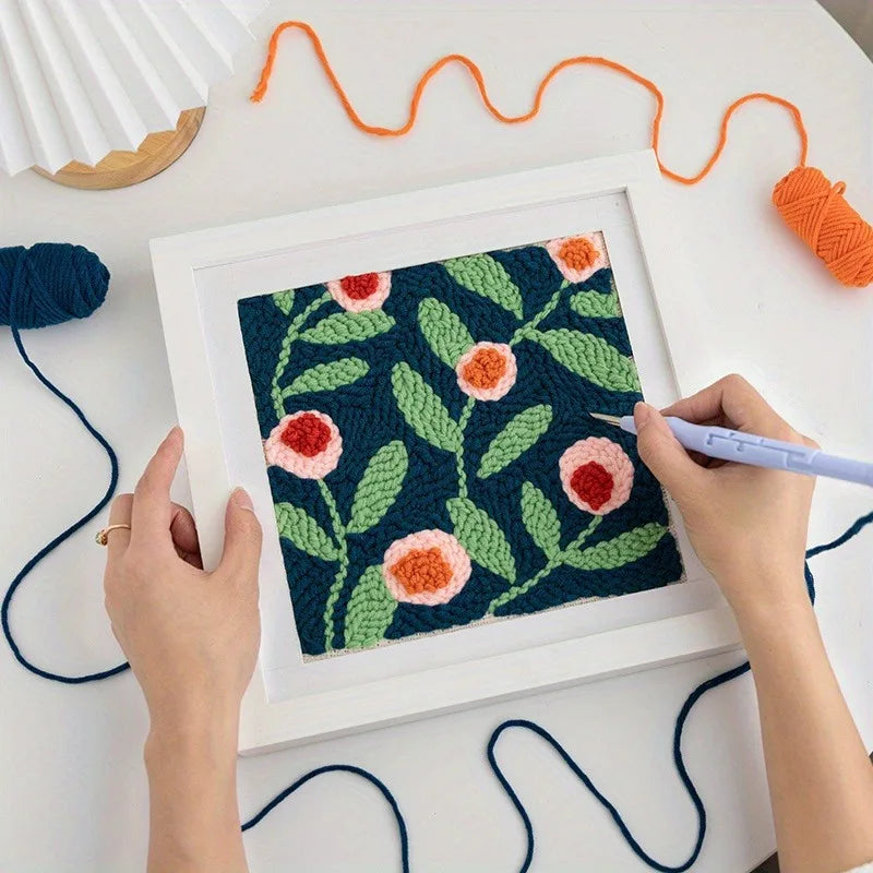Bilde med blomster laget med punch needle i en hvit ramme