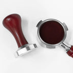 Tamperen ligger ved siden av en filterholder med tampet kaffe