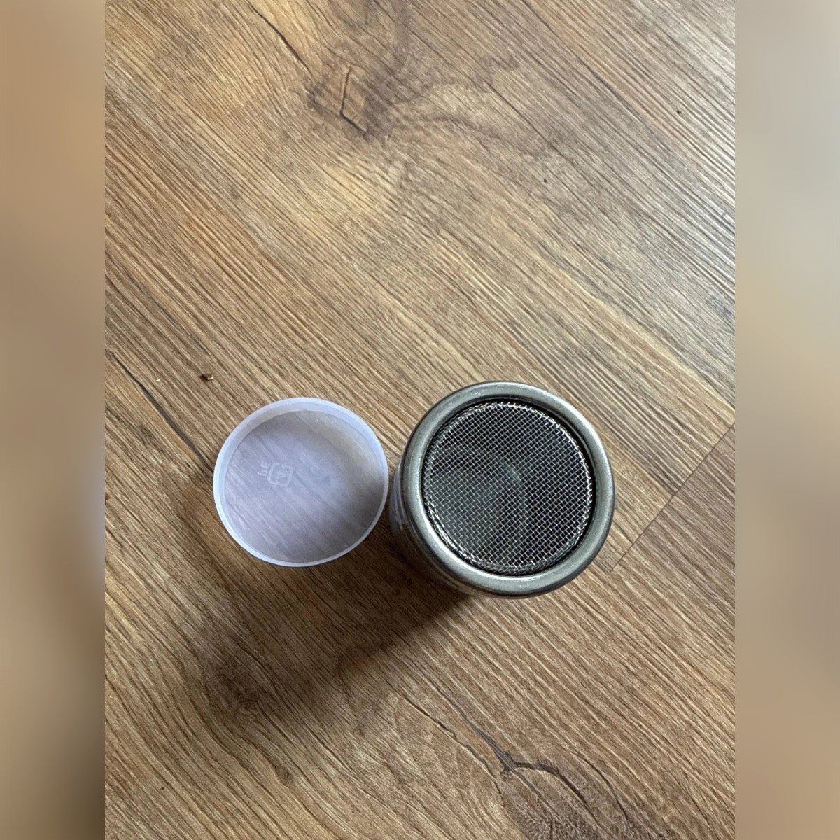 Kjøperbilde: sukkerstrøeren med nettet opp og plastlokket ved siden av