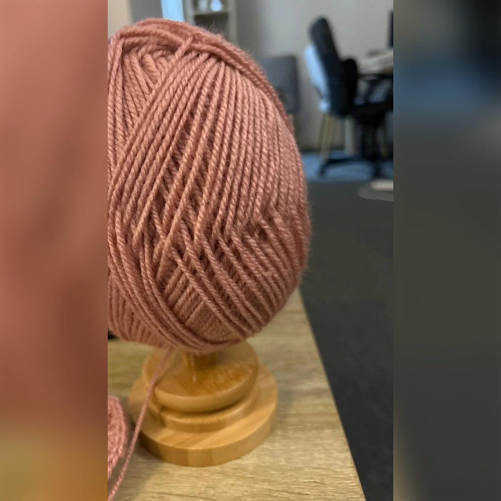Kjøpers bilde: rosa garnnøste på garnholderen på et bord