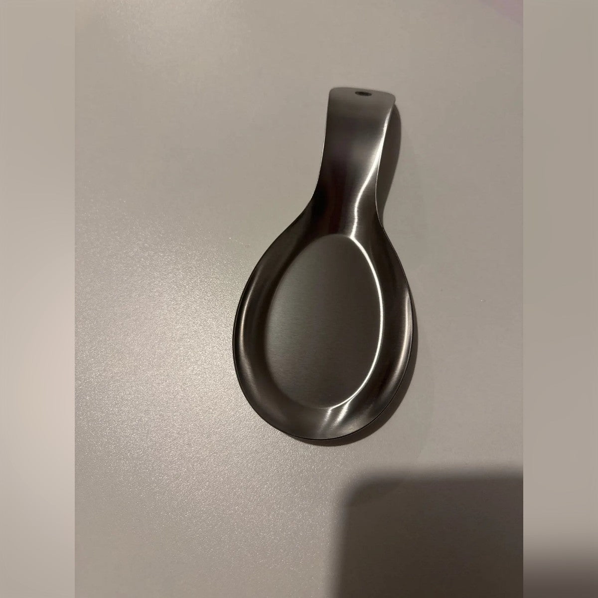 Kundebilde: skjeholderen på et grått bord, med hullet synlig