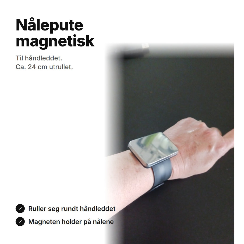 Svart magnetisk nålepute på et armbånd rundt håndleddet, ca. 24 cm utrullet