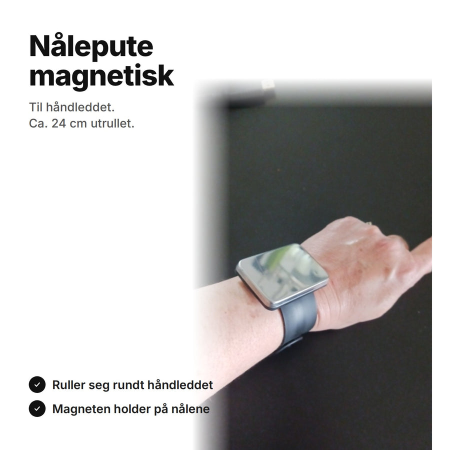 Svart magnetisk nålepute på et armbånd rundt håndleddet, ca. 24 cm utrullet