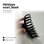 Blank svart hårklype, ca. 11 cm lang, 5 cm høy og 4,5 cm tykk
