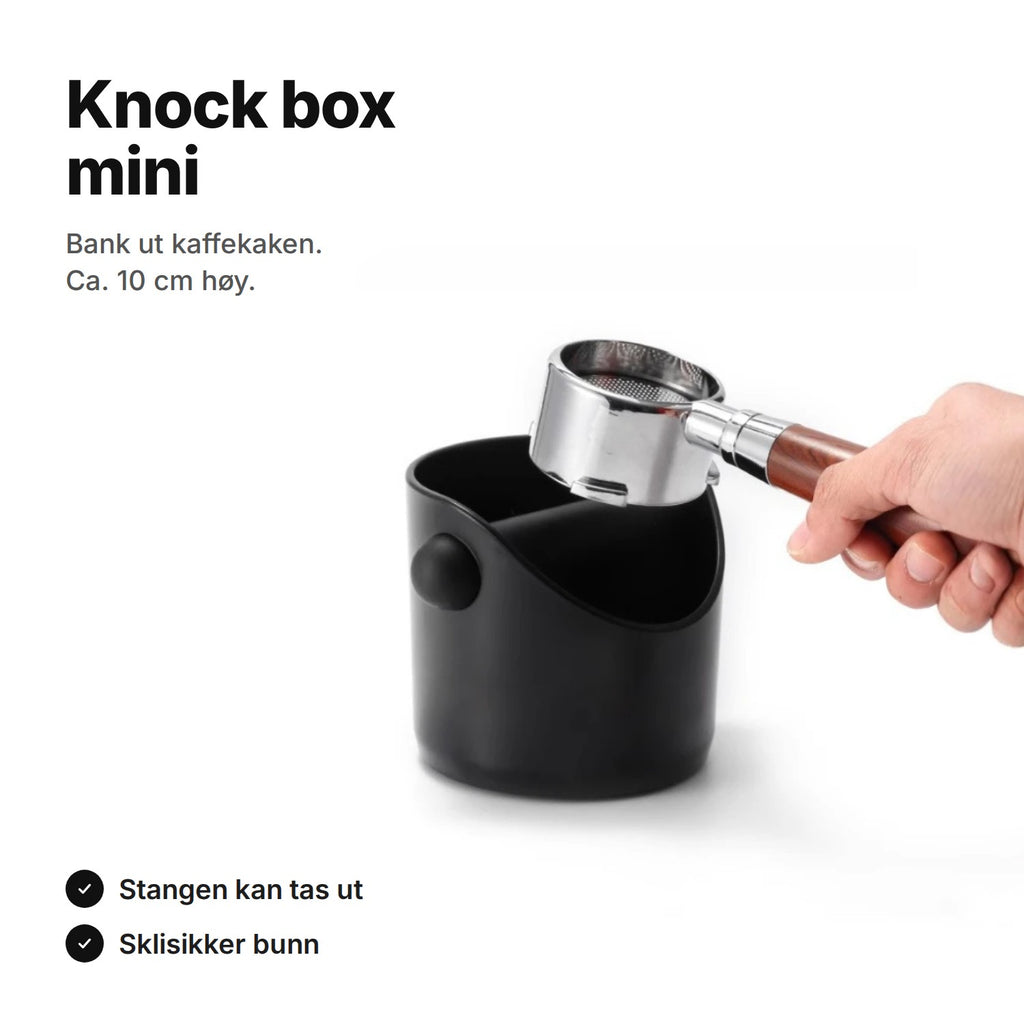 Knock box mini i svart med en filterholder holdt over boksen – ca. 10 cm høy, stangen kan tas ut