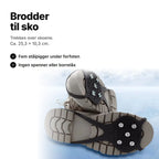 Brodder til sko i svart gummi under to vinterstøvler – ca. 25,3 × 10,3 cm, fem stålpigger under forfoten