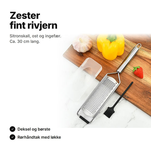 Zester i rustfritt stål med deksel og rengjøringsbørste på et skjærebrett – ca. 30 cm lang