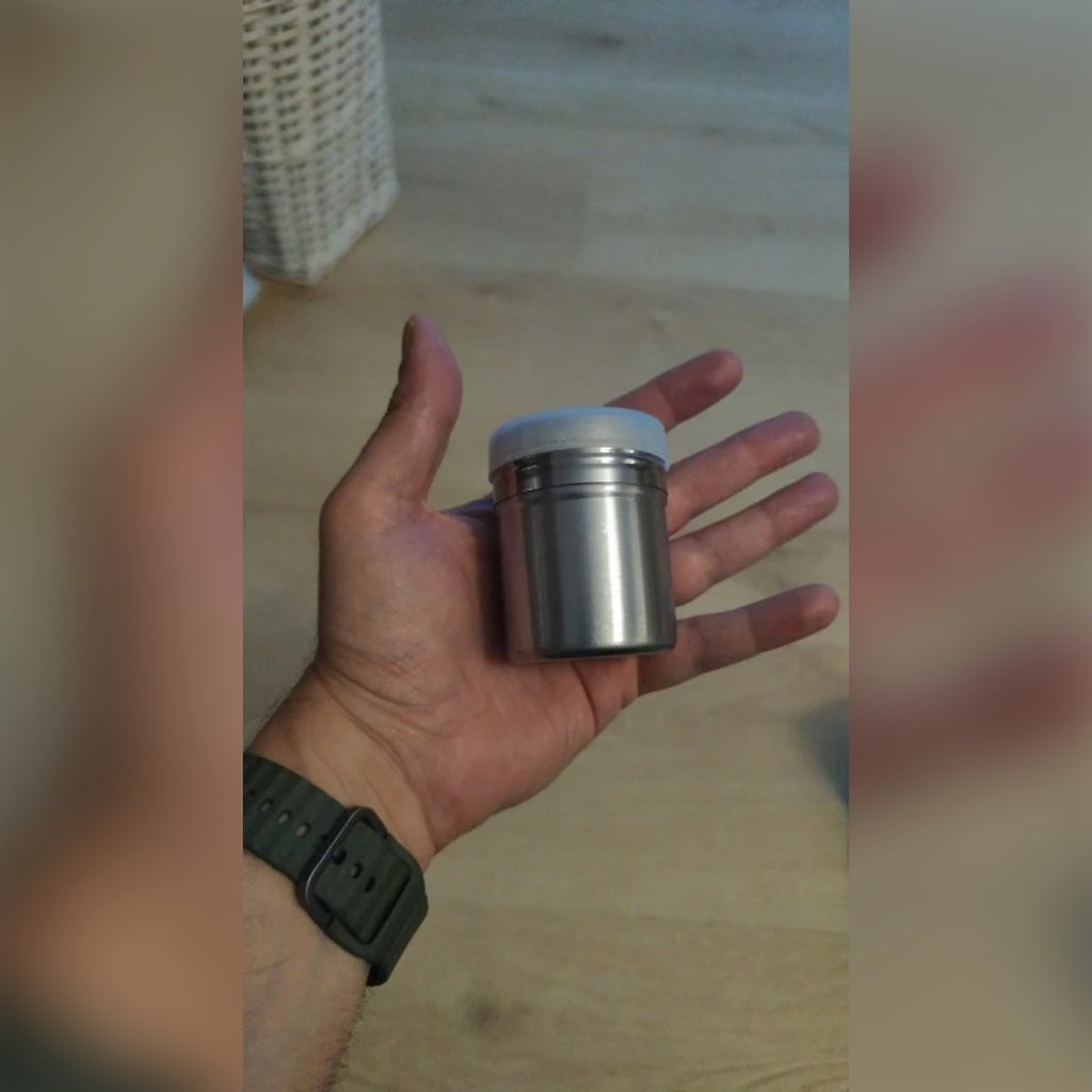 Kjøperbilde: sukkerstrøeren med plastlokk i en åpen hånd, som viser størrelsen