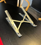 Kundebilde: laptopstativet i aluminium slått ut på et svart bord