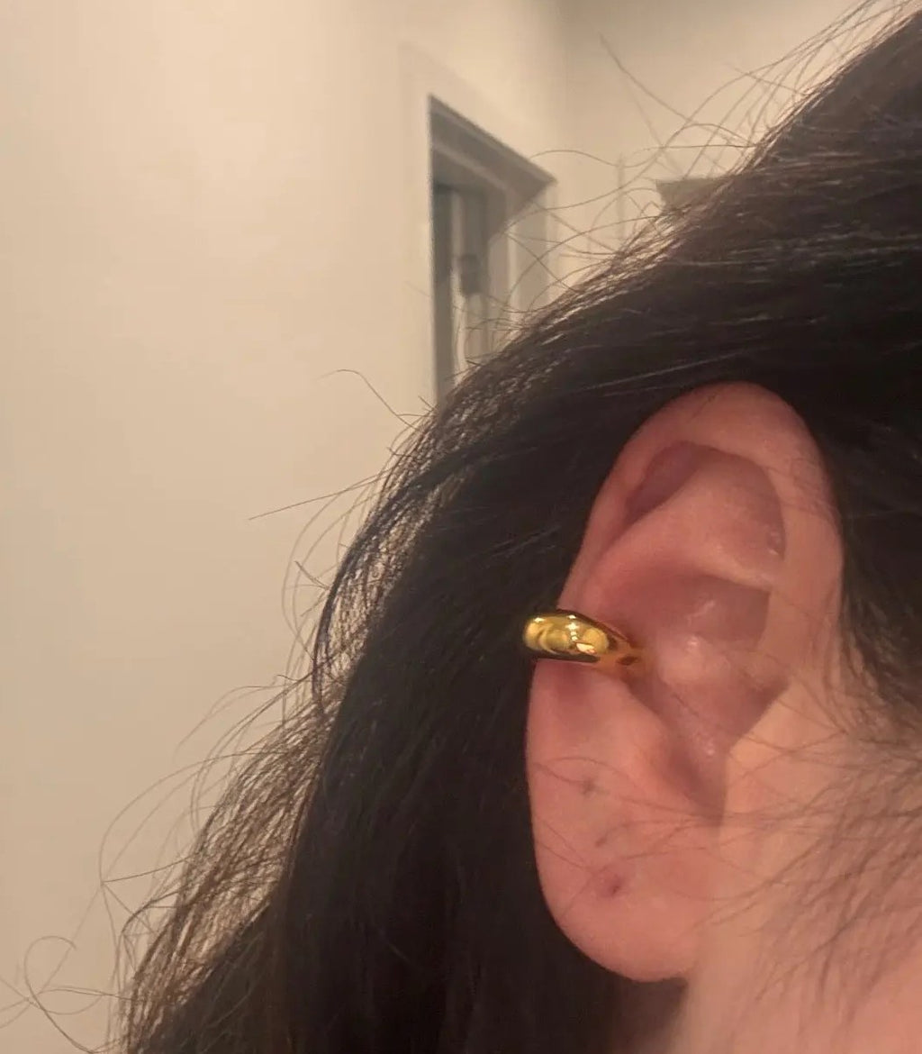 Kundens bilde: tykk gullfarget ear cuff på et øre