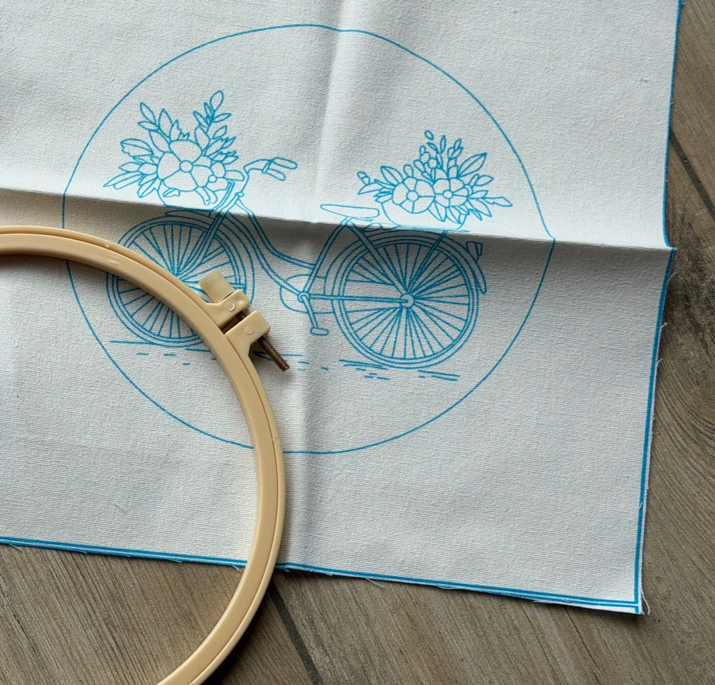 Kundens bilde: stoffet med det trykte sykkelmotivet og broderirammen