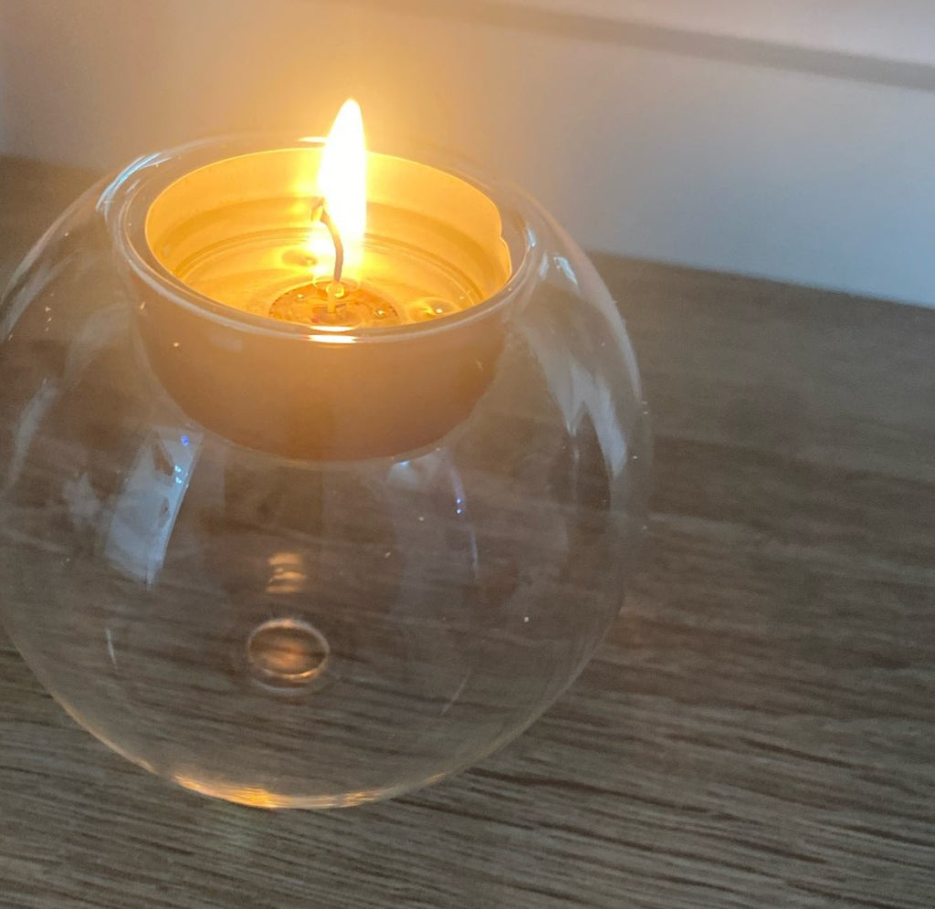 Kundens bilde: tent telys i glasskula på et trebord