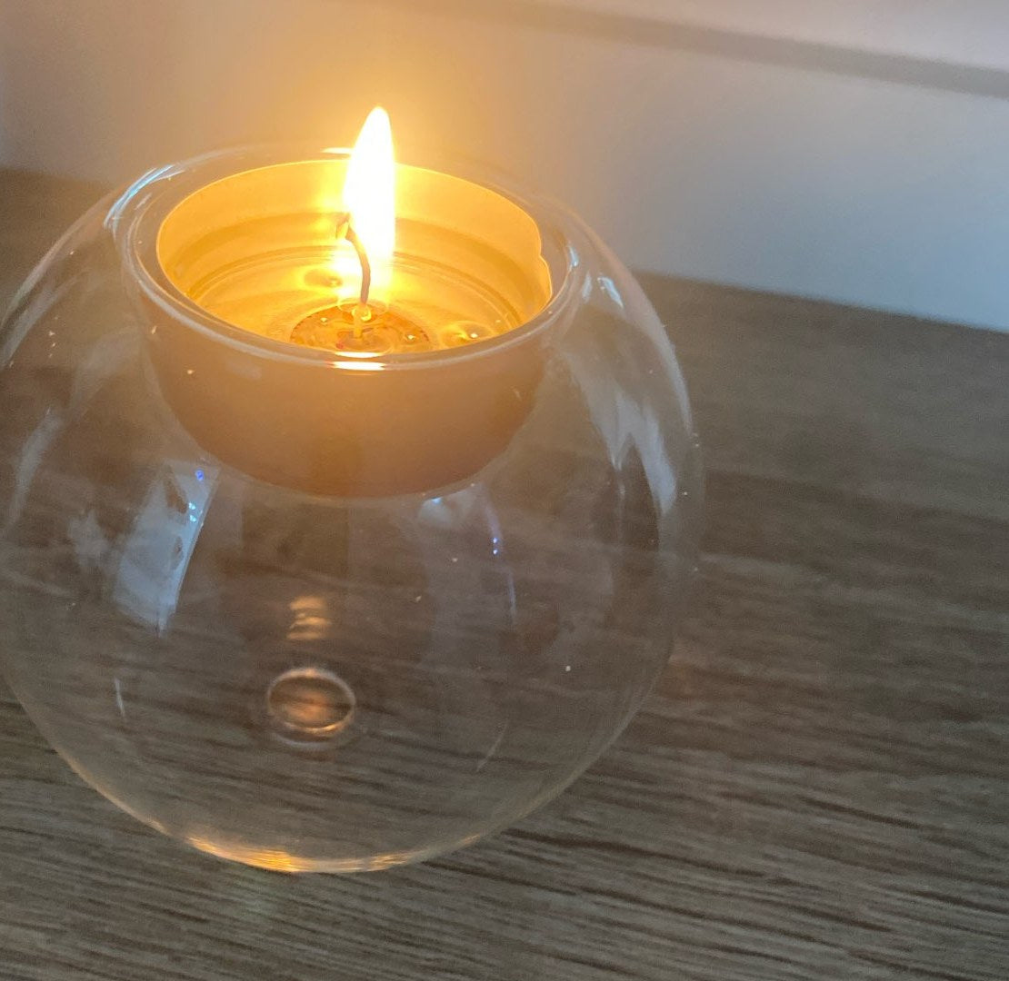 Kundens bilde: tent telys i glasskula på et trebord