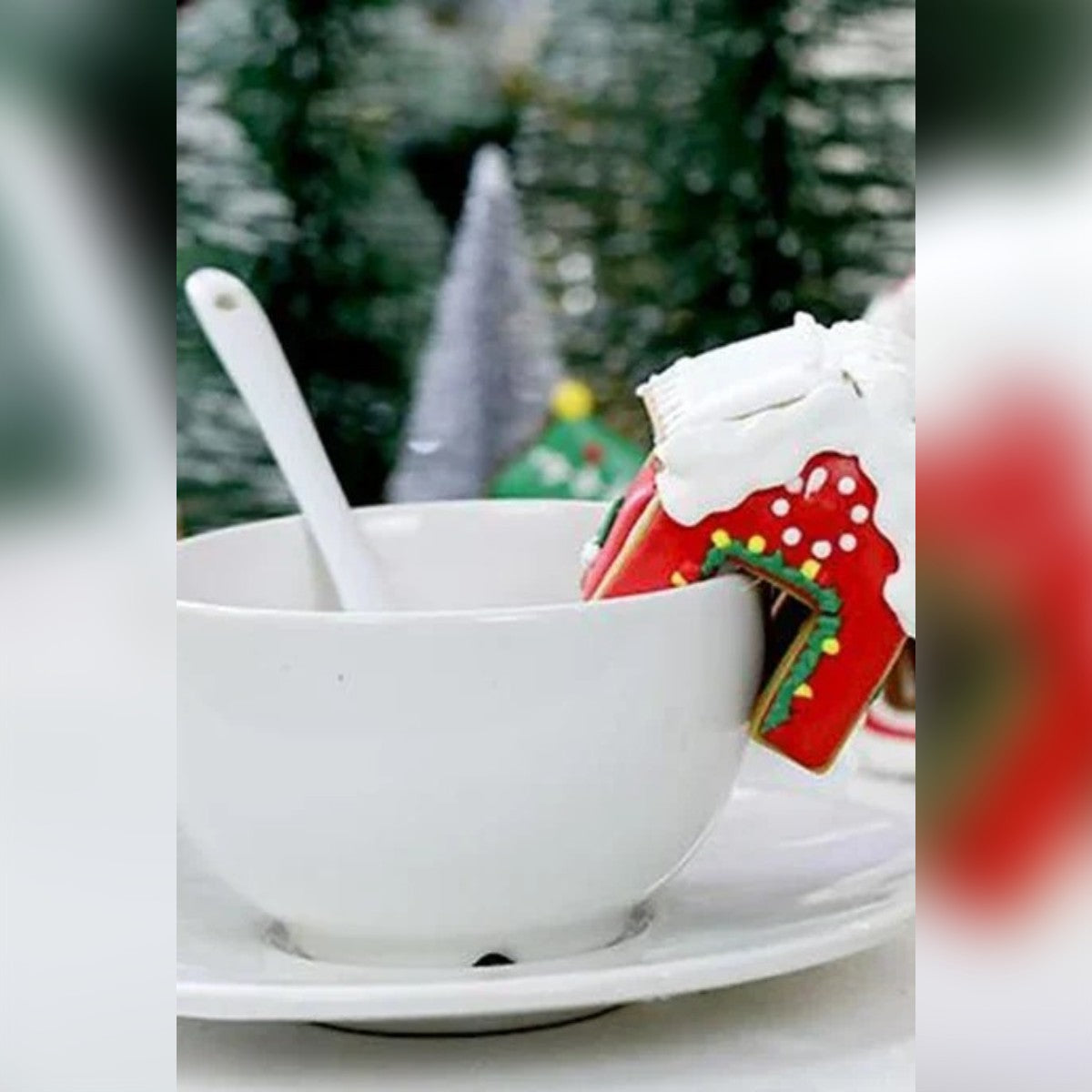 Pyntet mini pepperkakehus på kanten av en kaffekopp